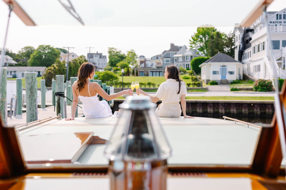two women on a boat clinking glasses